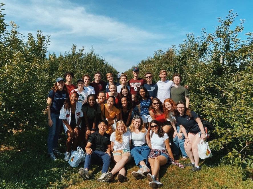 Glee Club members gathered in a field and smiling for the camera